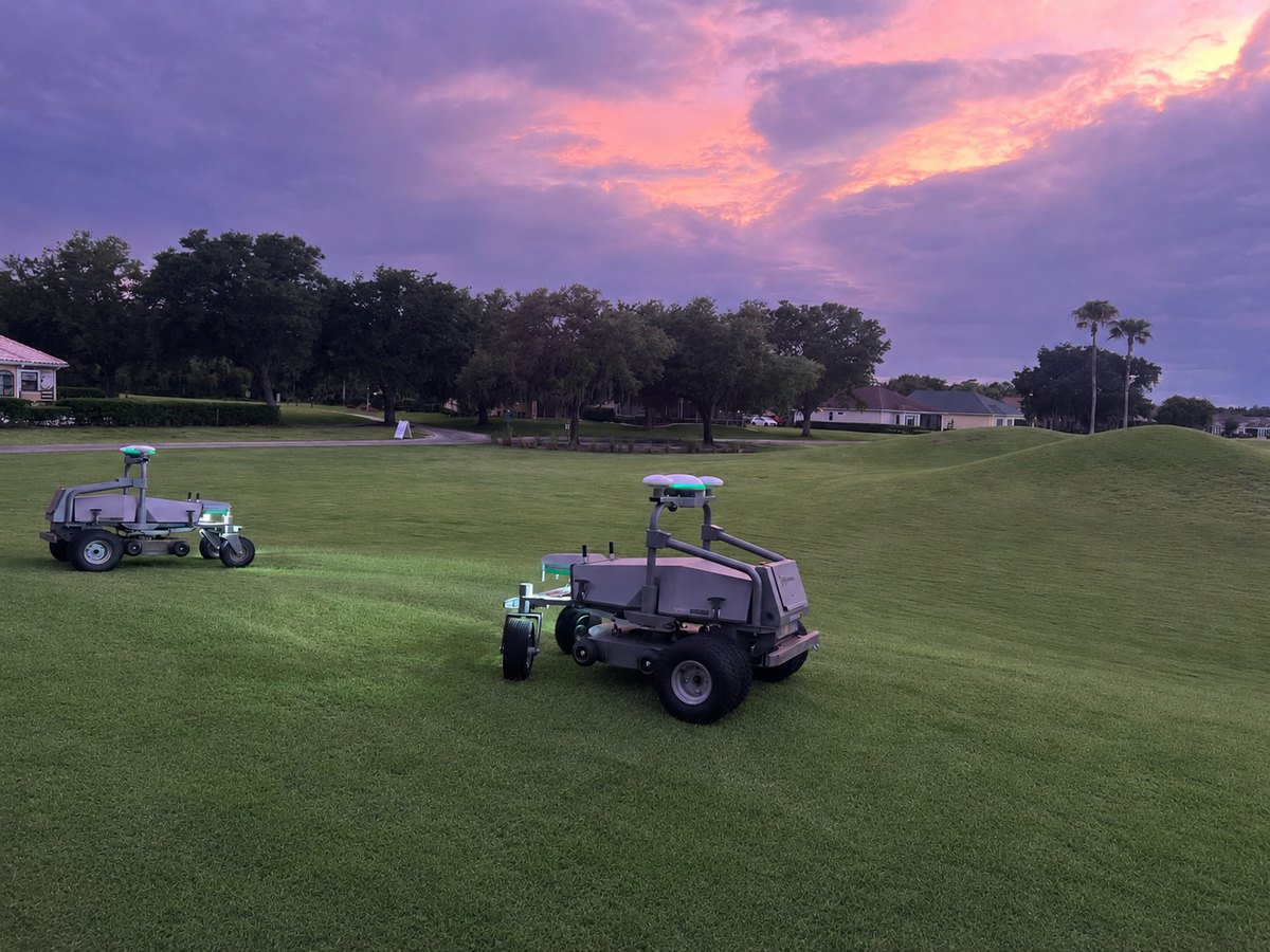Two FJD RM21 mowers up close on the course at LPGA International under a sunset sky